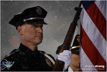 Honor Guard officer in serious pose with American Flag, while snow falls